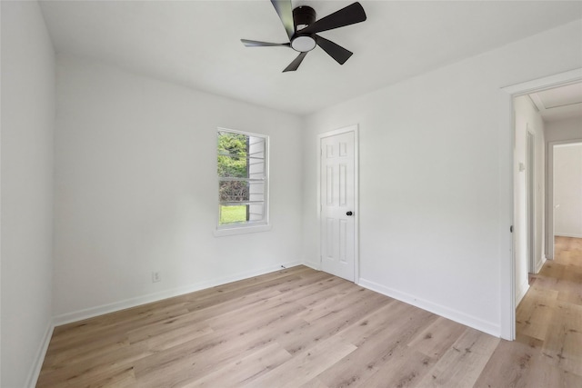 empty room with baseboards, a ceiling fan, and light wood finished floors