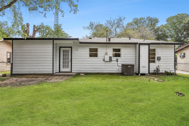 back of house featuring a lawn, central AC, and fence