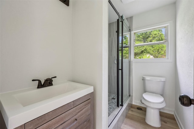 full bath with vanity, a shower stall, toilet, and wood finished floors