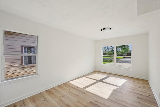 unfurnished room with baseboards and wood finished floors