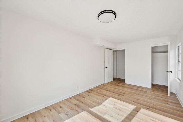 unfurnished bedroom featuring light wood-style floors and baseboards