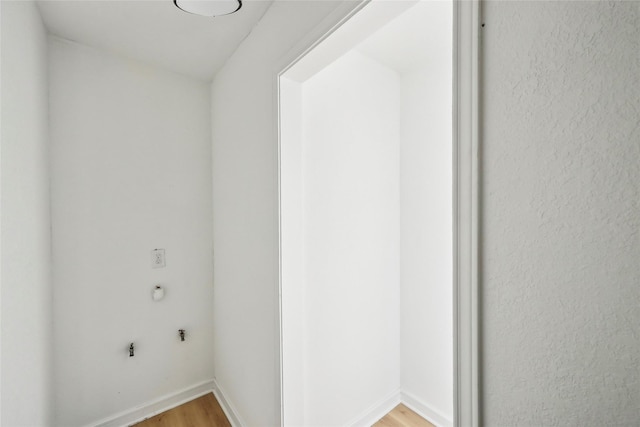 washroom with baseboards and light wood-style flooring