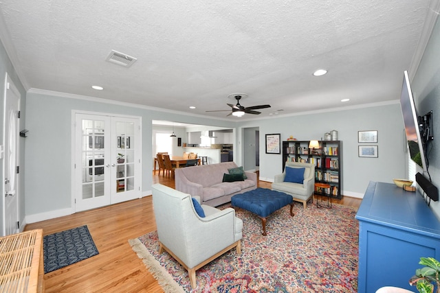 living room featuring a textured ceiling, a ceiling fan, recessed lighting, wood finished floors, and visible vents