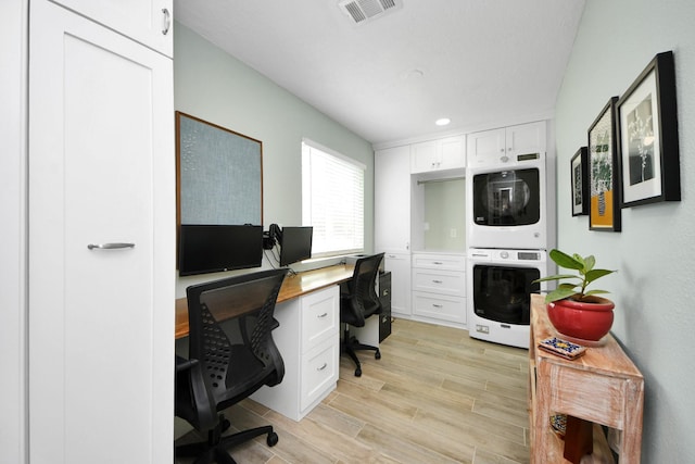 office space featuring recessed lighting, stacked washer and clothes dryer, light wood finished floors, and visible vents