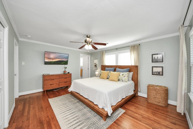 bedroom featuring crown molding, baseboards, and wood finished floors