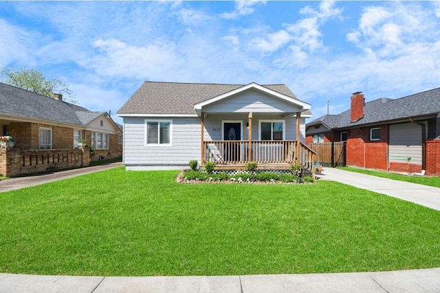 bungalow with a porch, fence, driveway, and a front yard