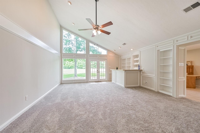 unfurnished living room featuring carpet floors, high vaulted ceiling, french doors, a ceiling fan, and visible vents