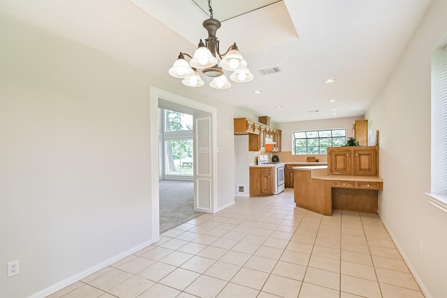 kitchen featuring an inviting chandelier, light tile patterned flooring, baseboards, light countertops, and white stove