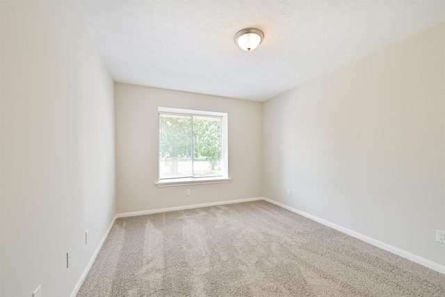 carpeted spare room featuring baseboards