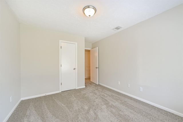 unfurnished room with visible vents, baseboards, and light carpet