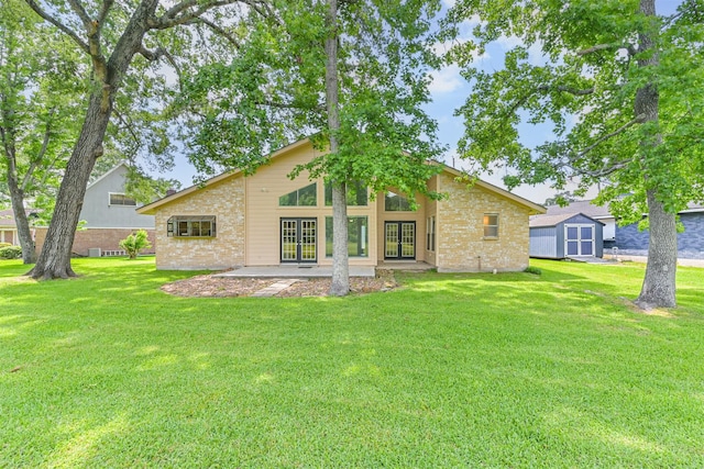back of house with a lawn, brick siding, french doors, and a storage unit