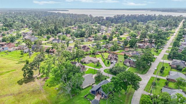aerial view featuring a water view, a view of trees, and a residential view