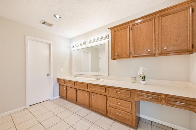 bathroom featuring tile patterned flooring, visible vents, vanity, baseboards, and a textured ceiling