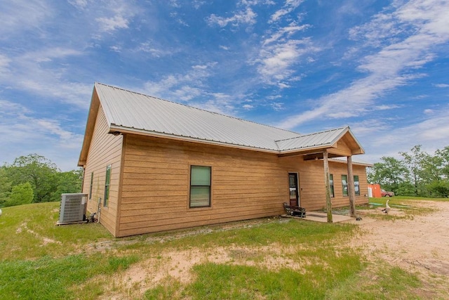 back of house featuring a yard, a patio, cooling unit, and metal roof