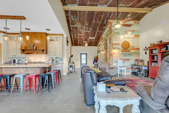 living area featuring wooden ceiling, ceiling fan, concrete flooring, and visible vents