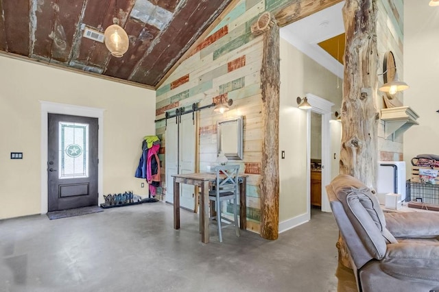 entrance foyer with visible vents, a barn door, concrete flooring, and high vaulted ceiling