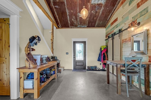interior space with a barn door, concrete floors, and wood ceiling