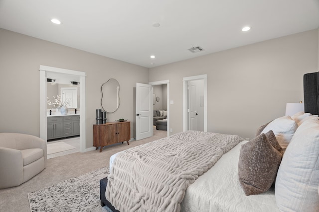 bedroom with visible vents, recessed lighting, ensuite bathroom, and light colored carpet