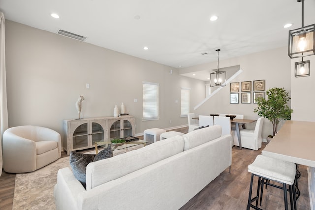 living room featuring recessed lighting, visible vents, dark wood finished floors, and an inviting chandelier