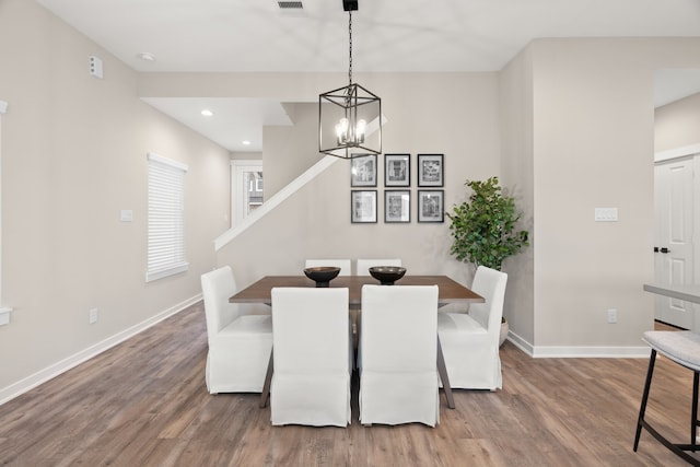 unfurnished dining area featuring visible vents, wood finished floors, baseboards, recessed lighting, and a chandelier