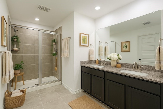 bathroom featuring a sink, tile patterned flooring, a stall shower, and visible vents