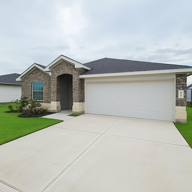 view of front of property featuring a garage, stone siding, a front yard, a shingled roof, and concrete driveway