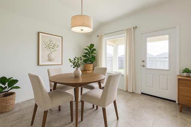 dining space with baseboards, vaulted ceiling, and light tile patterned floors