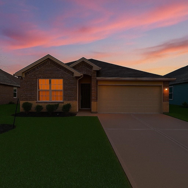 single story home featuring concrete driveway, brick siding, a lawn, and a garage