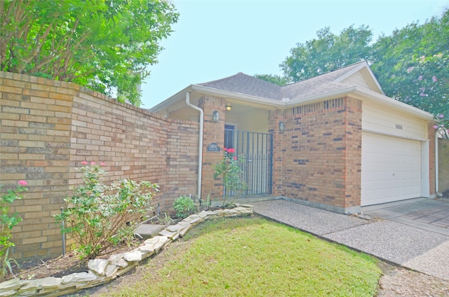 16806 Ashmoor Way, Houston, TX 77058 - view of side of home featuring an attached garage, brick siding, driveway, and a gate