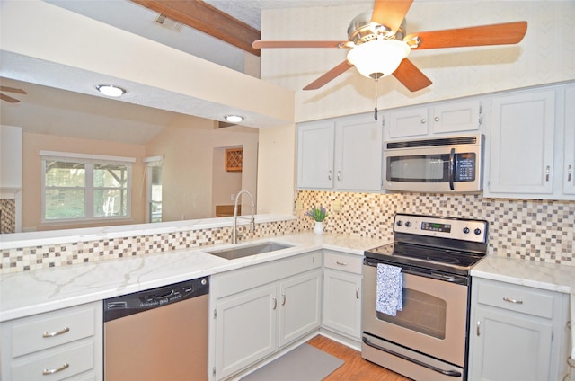 16806 Ashmoor Way, Houston, TX 77058 - kitchen with appliances with stainless steel finishes, a sink, a ceiling fan, decorative backsplash, and lofted ceiling