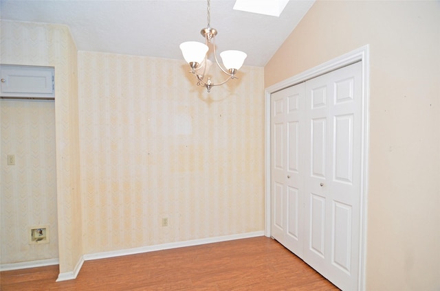 16806 Ashmoor Way, Houston, TX 77058 - unfurnished dining area featuring wood finished floors, a chandelier, a skylight, wallpapered walls, and baseboards