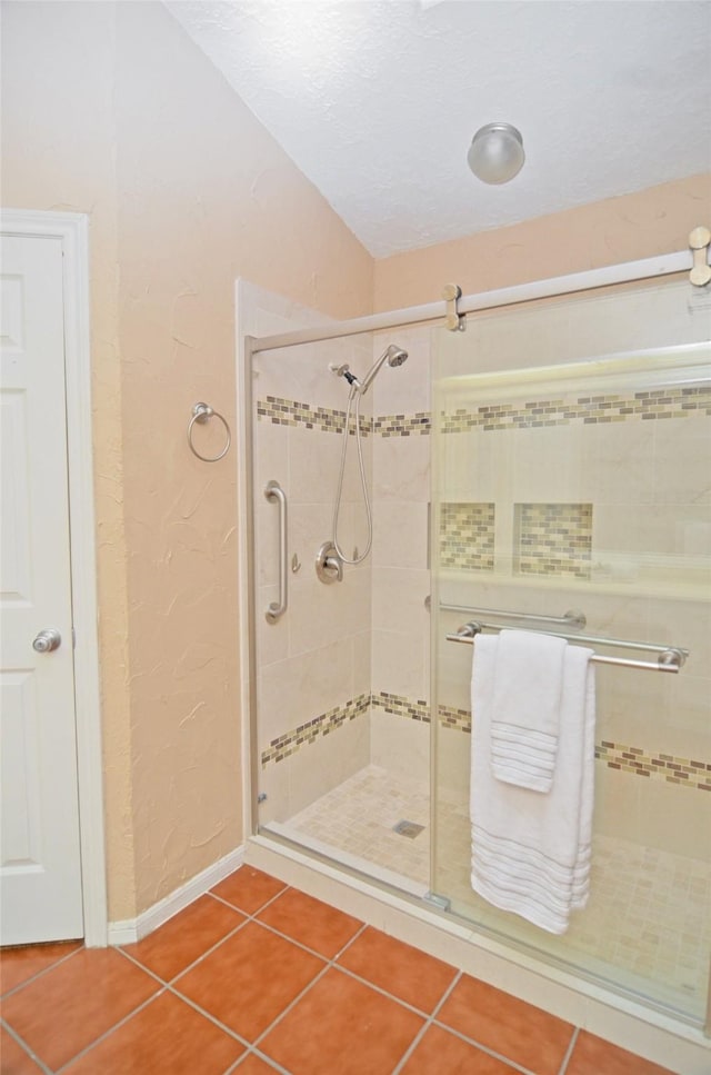 16806 Ashmoor Way, Houston, TX 77058 - bathroom with a stall shower, tile patterned floors, a textured wall, a textured ceiling, and baseboards