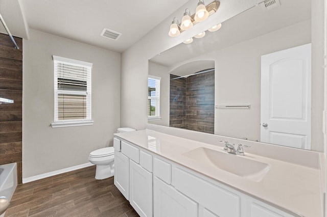 bathroom with toilet, visible vents, a wealth of natural light, and wood finished floors
