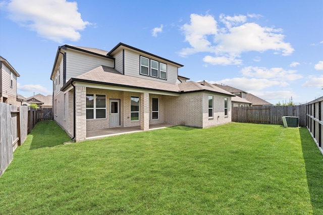 back of property featuring a yard, brick siding, a fenced backyard, and a patio area