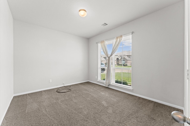 carpeted empty room featuring visible vents and baseboards