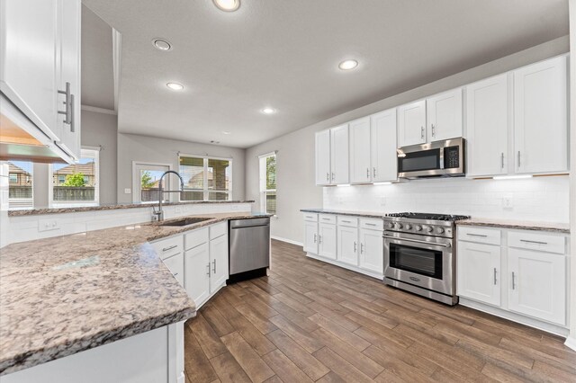 kitchen with white cabinets, stainless steel appliances, recessed lighting, and a sink
