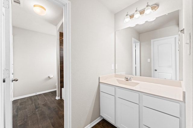 bathroom with visible vents, baseboards, wood finished floors, and vanity