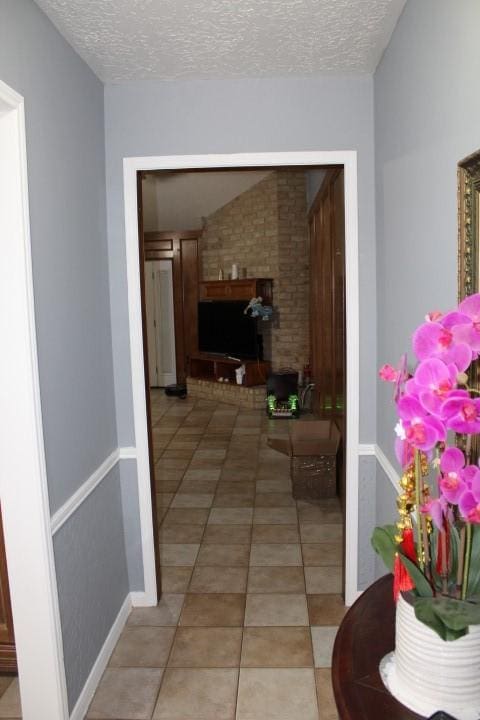 9222 Chesney Downs Dr, Houston, TX 77083 - hallway with a textured ceiling and light tile patterned flooring