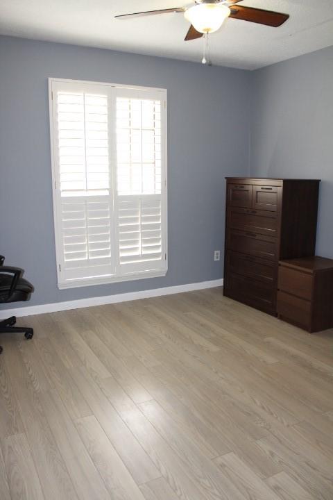9222 Chesney Downs Dr, Houston, TX 77083 - unfurnished bedroom with light wood finished floors, baseboards, and ceiling fan