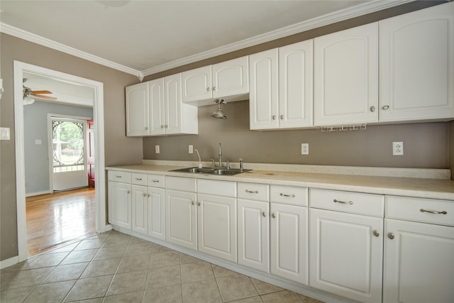 1622 Jennifer Ln, Houston, TX 77029 - kitchen with a sink, light countertops, crown molding, and white cabinetry