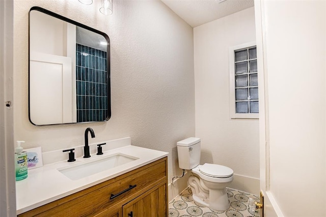 bathroom featuring vanity, tile patterned floors, baseboards, and toilet