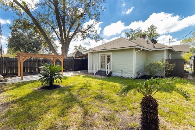 back of house featuring entry steps, a fenced backyard, french doors, a patio, and a yard