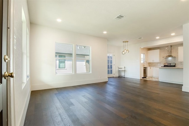 unfurnished living room featuring baseboards, recessed lighting, and dark wood-style flooring