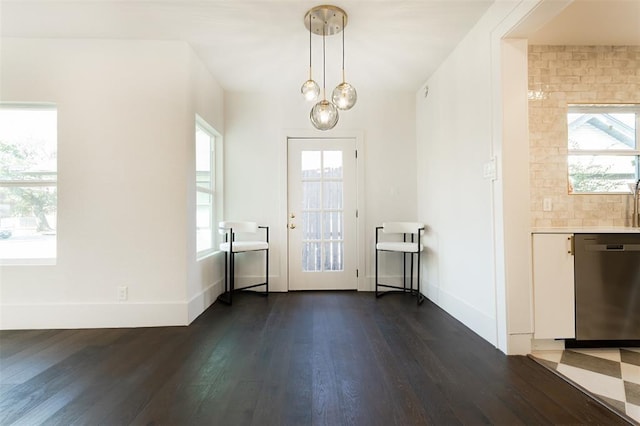 doorway to outside featuring baseboards and dark wood finished floors