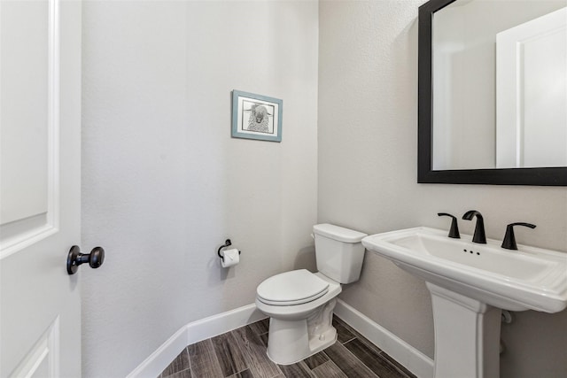 2802 Tarragon Crest Dr, Katy, TX 77494 - half bath with toilet, baseboards, wood finish floors, and a sink