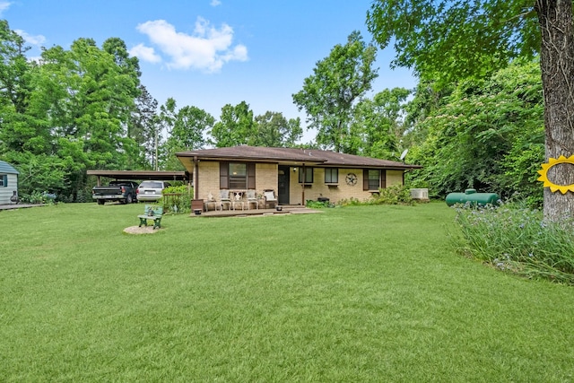 rear view of house with a lawn, a porch, brick siding, and a carport