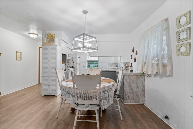 dining room with wood finished floors and a chandelier
