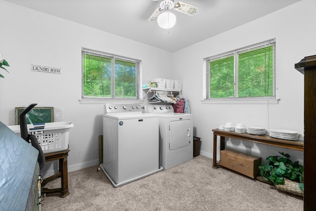 laundry area with laundry area, a ceiling fan, washing machine and dryer, and a wealth of natural light