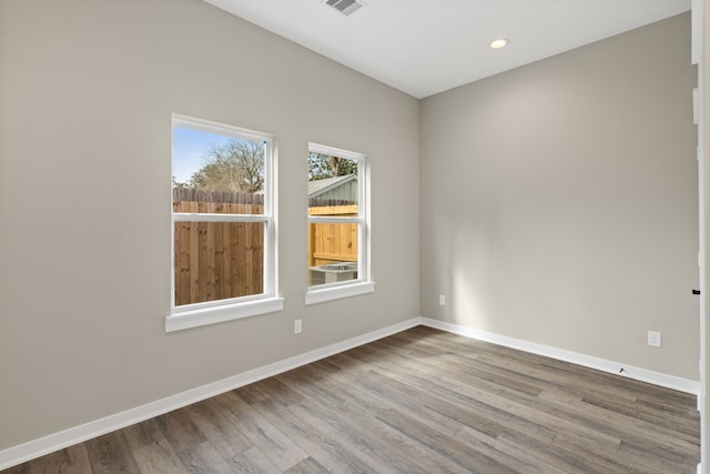 empty room featuring recessed lighting, baseboards, and wood finished floors