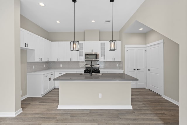 kitchen with backsplash, white cabinets, and stainless steel appliances